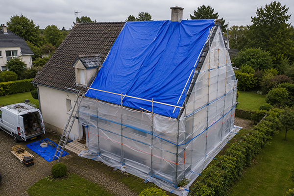 Exemple d'intervention de bâchage toiture en Nouvelle-Aquitaine après des dégâts causés par les intempéries. La protection provisoire de la toiture et de la façade permet de limiter les infiltrations d'eau jusqu'à la réparation complète de la couverture.